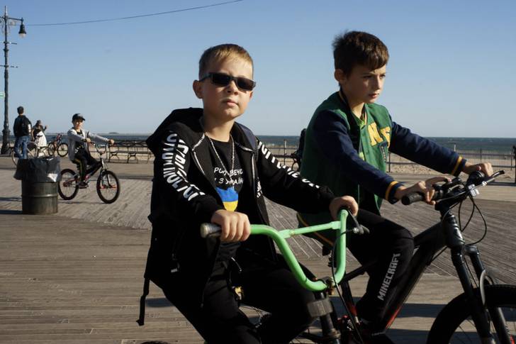 kids on bikes on the Brighton Beach boardwalk